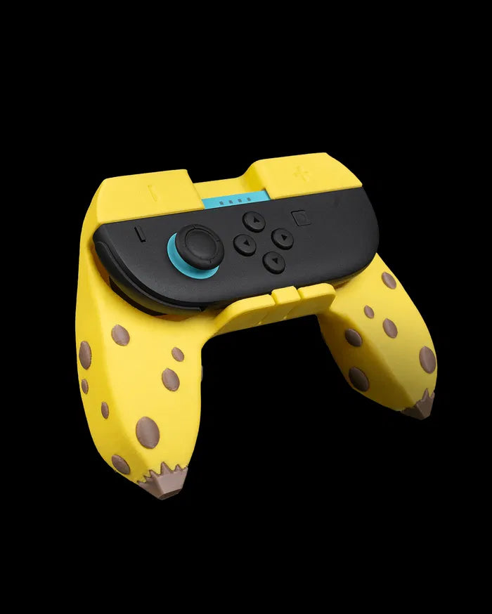 Angled view of a yellow banana-themed controller grip with brown spots and black controller controls