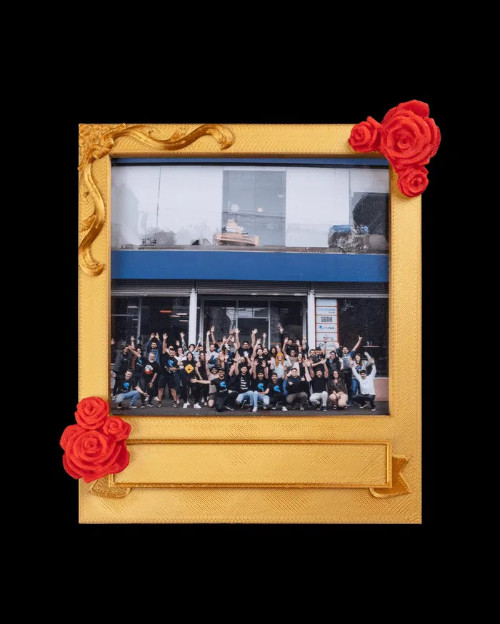 Gold-toned photo frame with red rose accents holding a group photo on a black background