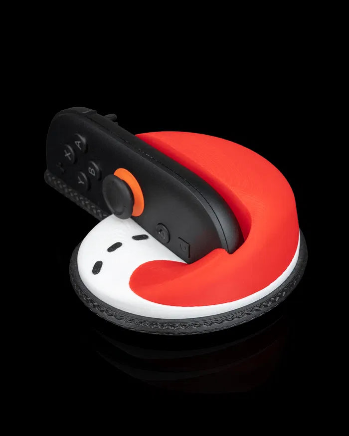 Black controller-like computer mouse in a red, white and black shaped grip on a black background
