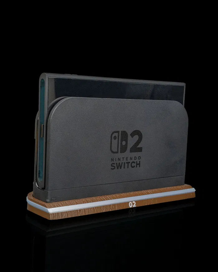 Angled front view of a black console dock on a wood-tone base with a side edge visible