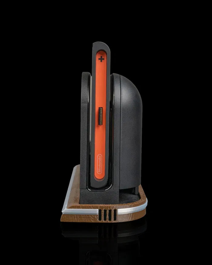 Side view of a console dock on a wood-tone base with an orange controller edge visible