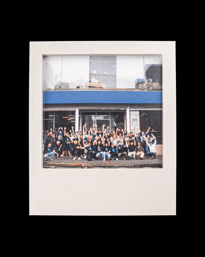 White instant-style photo frame holding a group photo on a black background