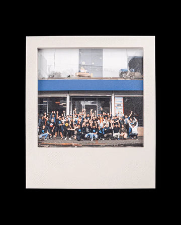White instant-style photo frame holding a group photo on a black background