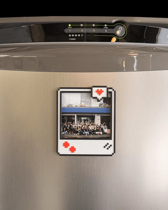 Pixel-style photo frame holding a photo on a metallic refrigerator door