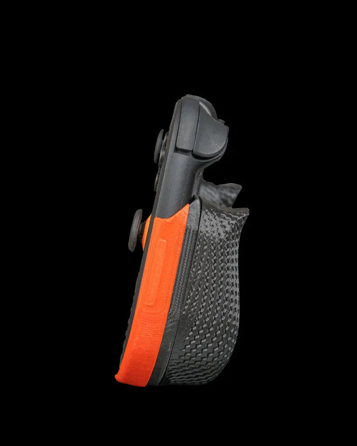 Side view of a black and orange controller grip with textured back surface