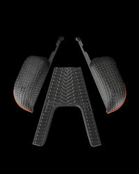 Separated black grip components with tread patterns and orange-edged side pieces