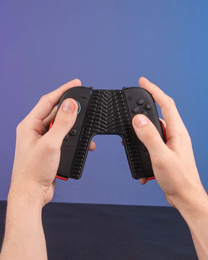 Hands holding a black controller grip with tire tread texture against a blue background