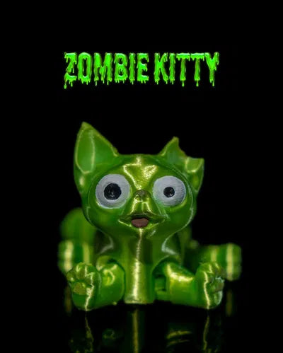 Green zombie cat figurine with one ear bitten off and a silly expression