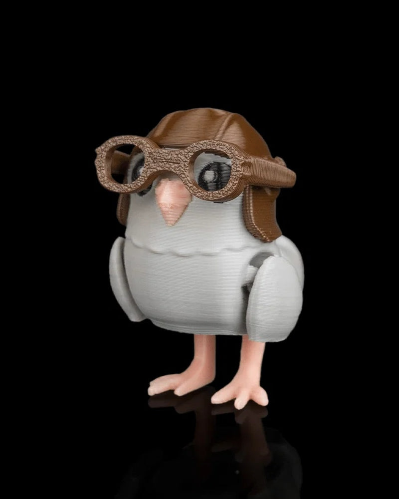 Small gray pigeon figurine shown from an angled front view with brown helmet and goggles
