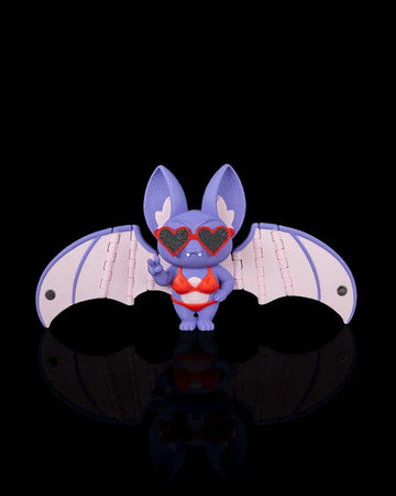 Purple bat figurine with pink wings, red swimwear, and heart-shaped sunglasses on a black background