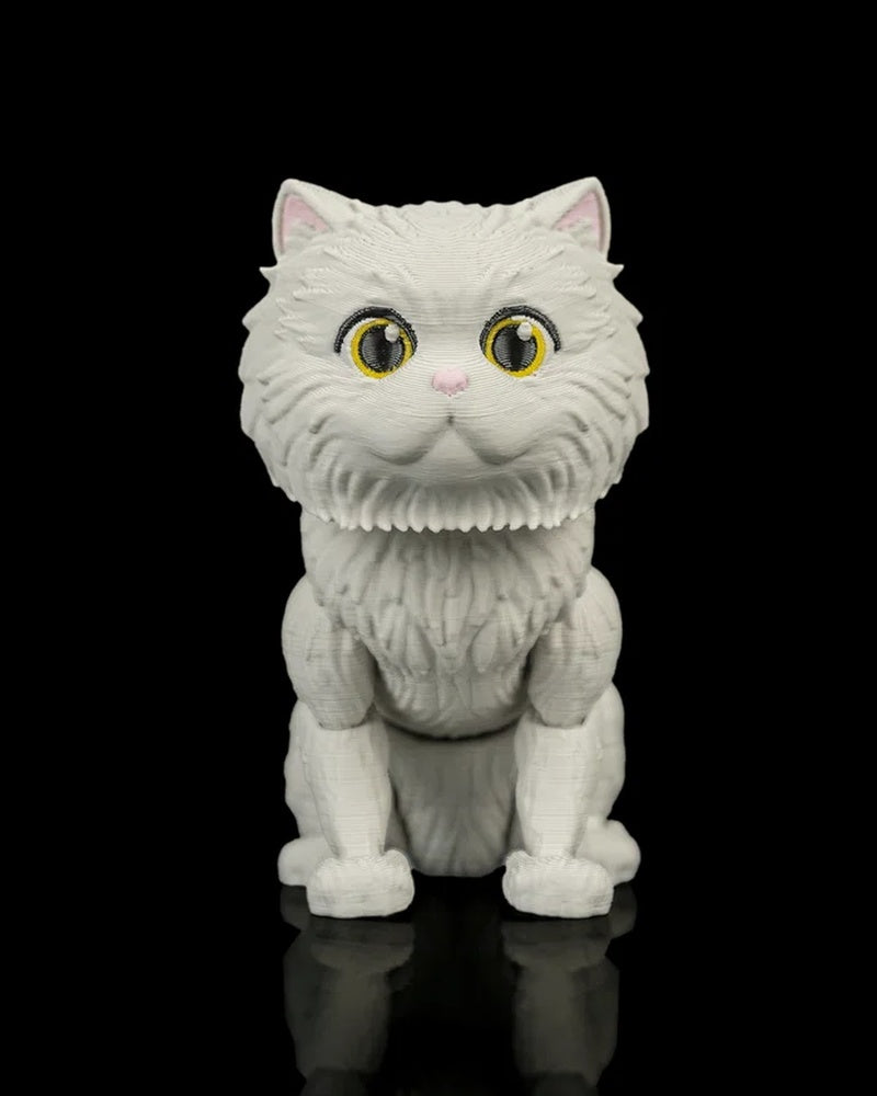 Front view of a white cat figurine with large yellow eyes, pink nose, and pink inner ears on a black reflective surface