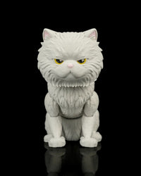 Front view of a white cat figurine with narrowed yellow eyes and a pink nose on a black reflective surface