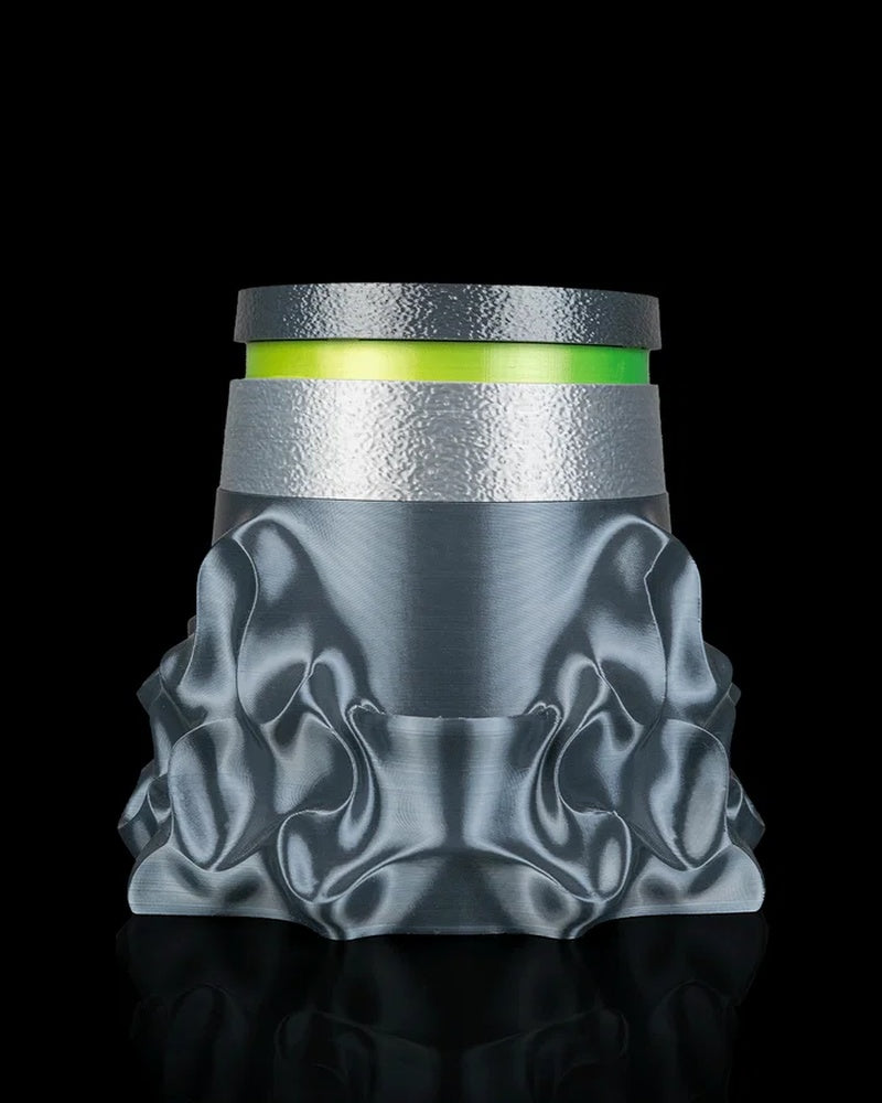 Close-up of a gray sculptural planter with green and silver ring details