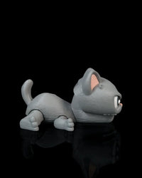Side view of a gray cat toy with pink inner ear, curled tail, and open mouth on a black surface