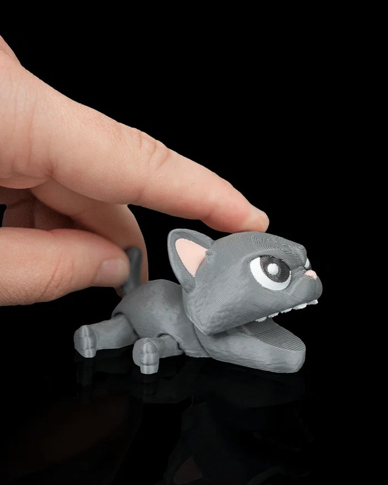 Gray cat toy with open mouth being pressed by a finger on a black surface