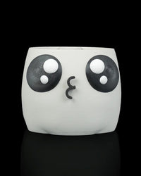 White face planter without a plant, showing large black-and-white eyes and a puckered mouth