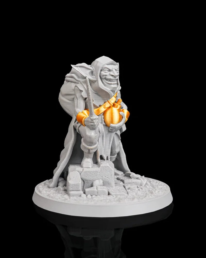 Side view of a gray goblin figurine with orange bomb accents, a blade, and a large pack on a round base