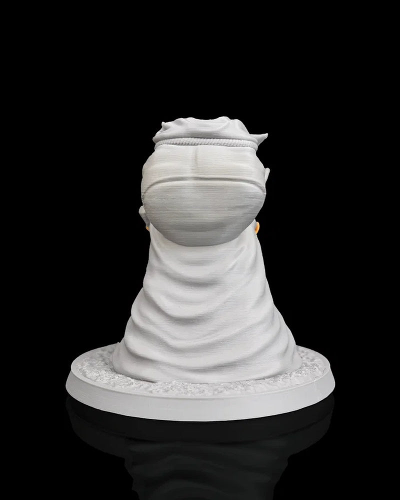 Rear view of a gray goblin figurine with a large pack and cloak on a round base