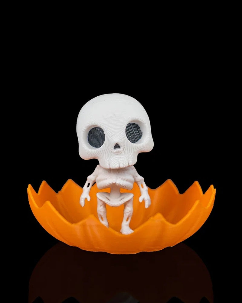 White skeleton figure sitting inside an orange jagged pumpkin shell on a black background