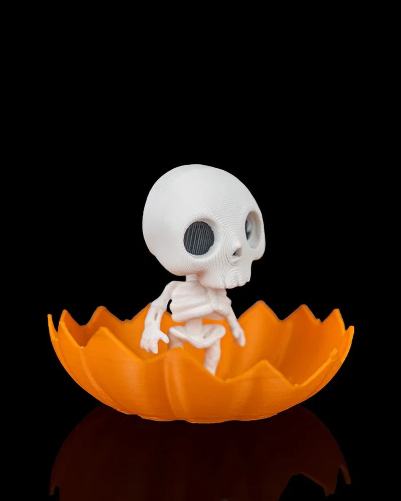 Side view of a white skeleton figure inside an orange jagged pumpkin shell on a black background