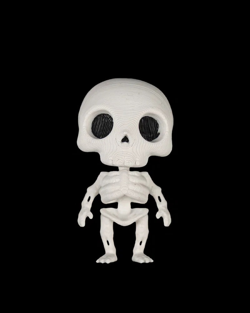 Front view of a small white skeleton figure with dark eye sockets on a black background