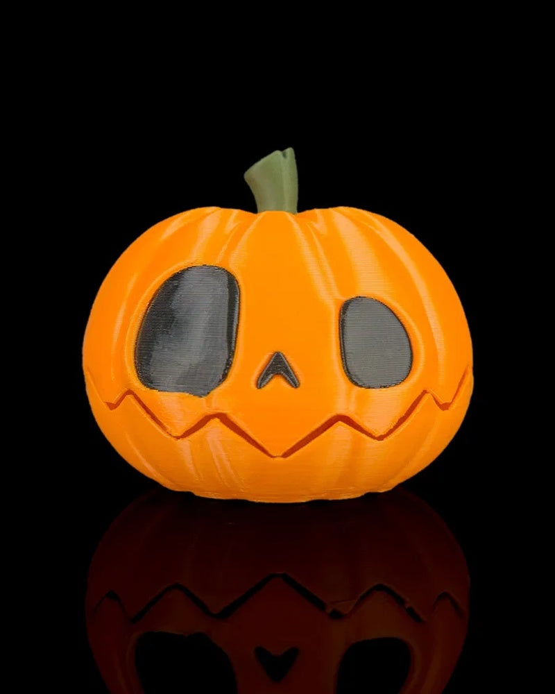 Orange pumpkin with dark eyes, small nose, green stem, and jagged mouth on a black background