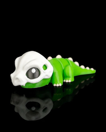 Green dinosaur figurine with a white skull head detail on a black reflective surface