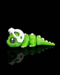Green dinosaur figurine in profile with a white skull detail over the head