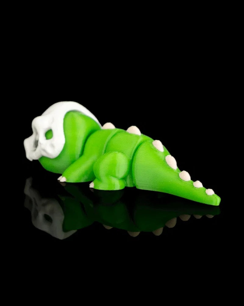 Rear side view of a green dinosaur figurine with white spikes along the tail