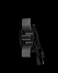 Gray ridged cord holder with a coiled black power cord on a black background
