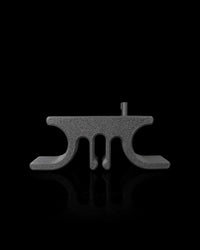Gray cord holder viewed from the side on a black reflective surface
