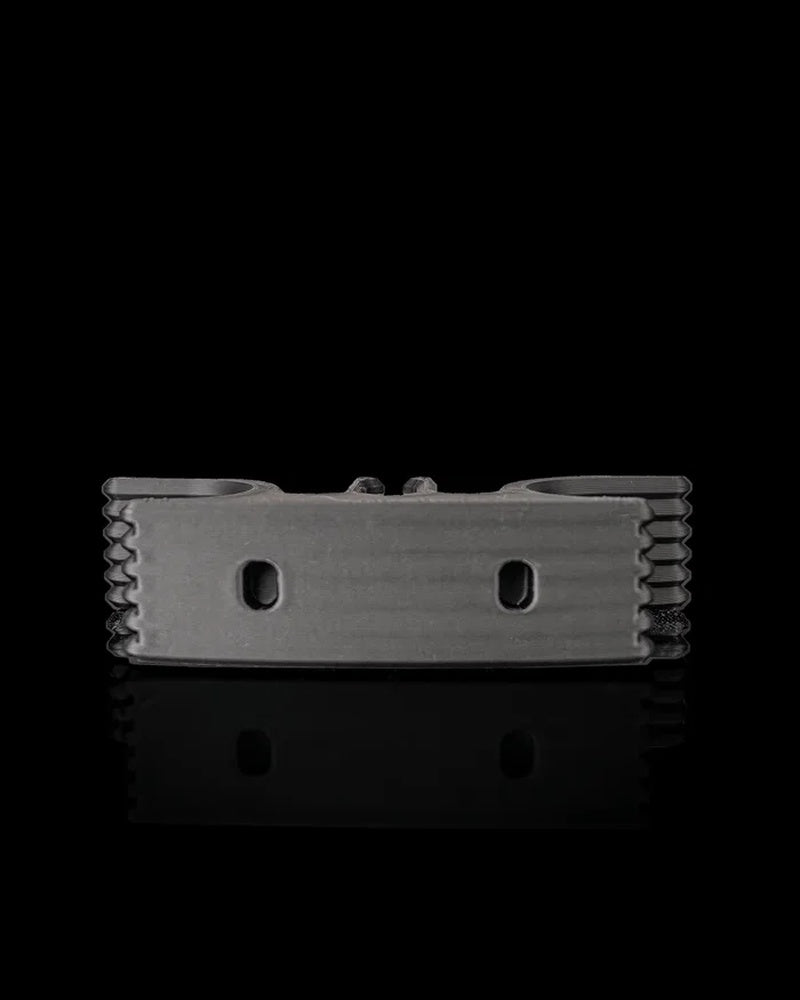 Gray cord holder viewed from the underside on a black reflective surface