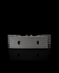 Gray cord holder viewed from the underside on a black reflective surface