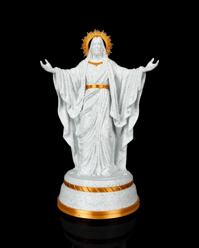Front view of a white and gold Christ statue on a round base without the base light showing