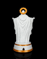 Back view of a white and gold Christ statue with a halo and round base