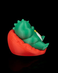 Rear side view of a green dinosaur figurine reclining in a red chair on a black background