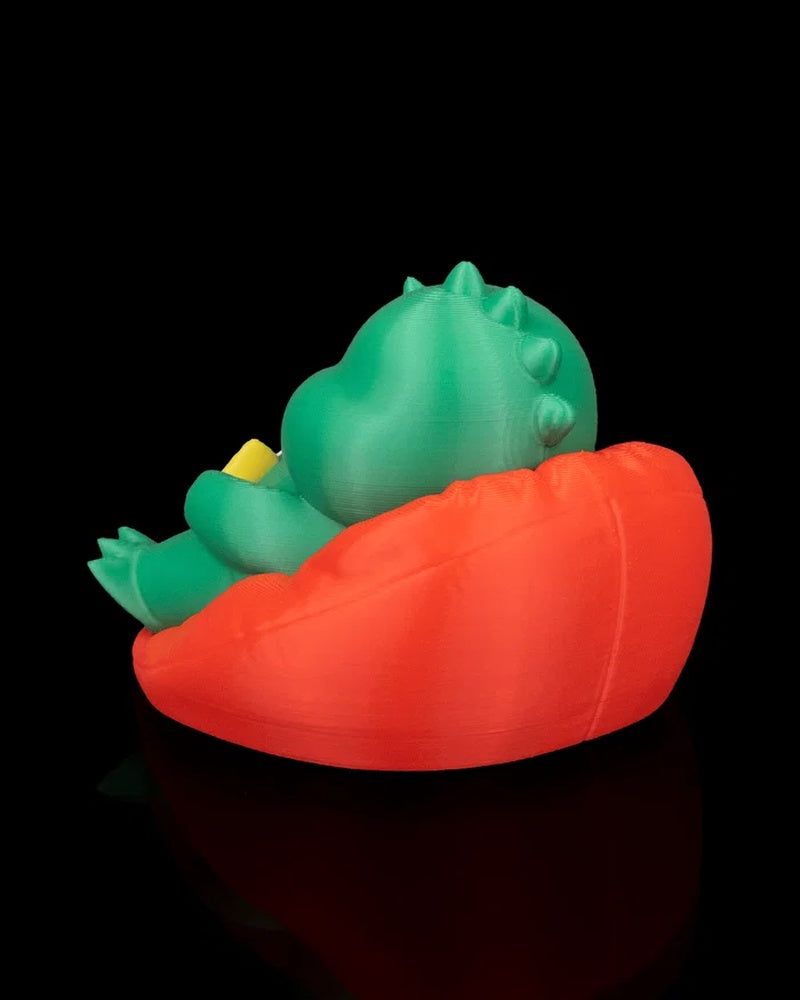 Side rear view of a green dinosaur figurine seated in a red chair with small back spikes visible
