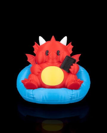 Front view of a red dragon figurine with white horns, yellow belly, small wings, and blue cushion on a black background.