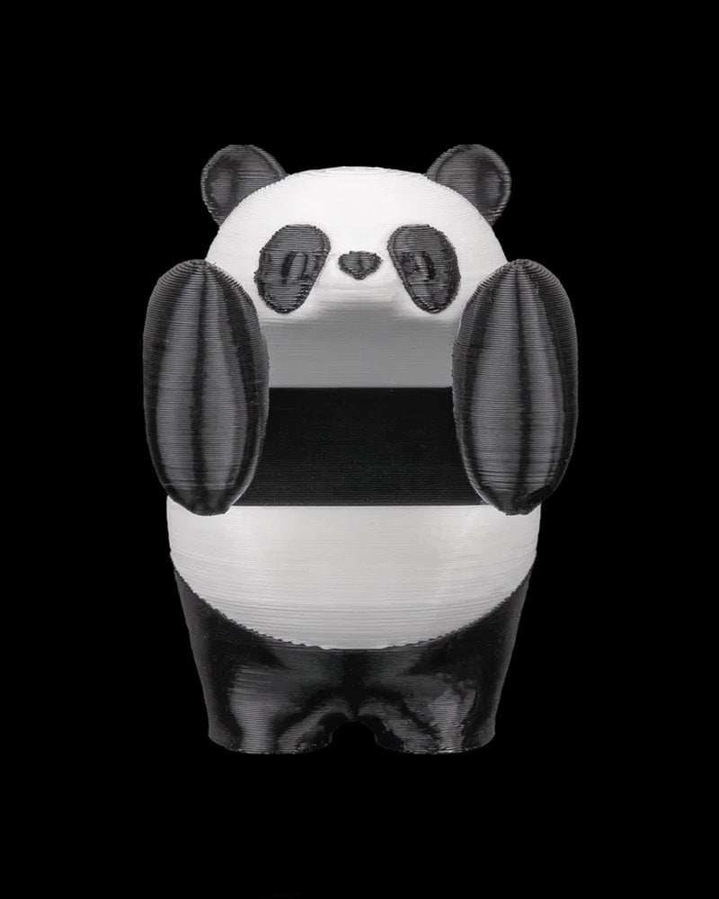 Front view of a black-and-white panda figurine with raised paws on a black background