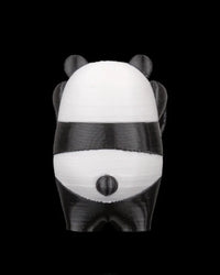 Back view of a black-and-white panda figurine with small tail on a black background