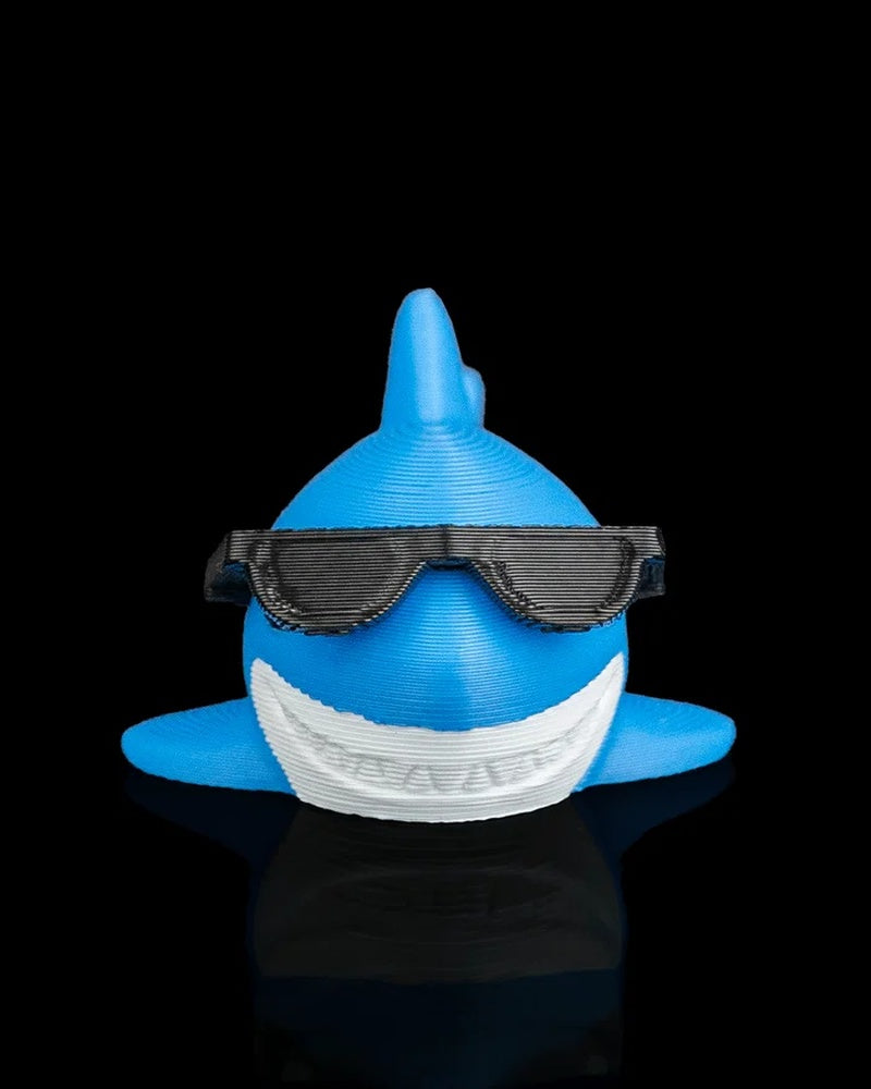 Front view of a blue shark figure with black sunglasses, a white grin, and side fins on a black background.