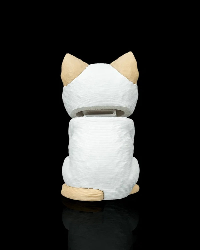 Rear view of a cream and white cat figure with tan ears and tail on a black background
