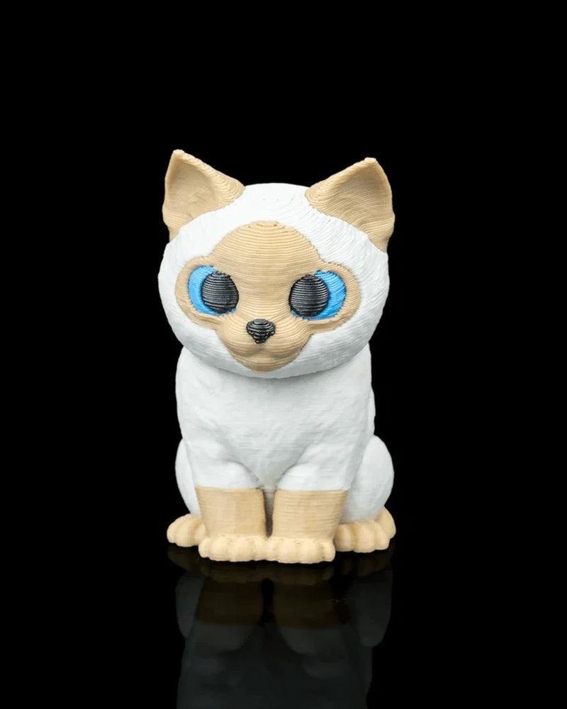 Front view of a seated cream and white Siamese cat figure with blue eyes on a black background