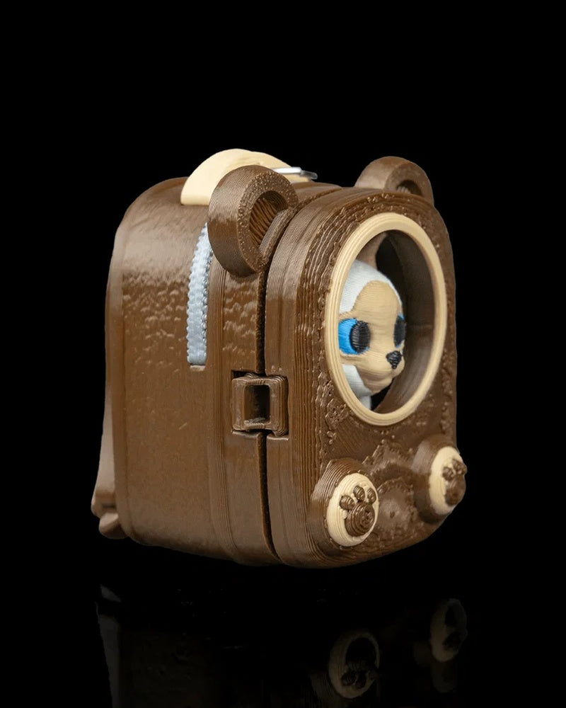Side view of a brown pack-shaped case with a Siamese cat face visible through a round opening