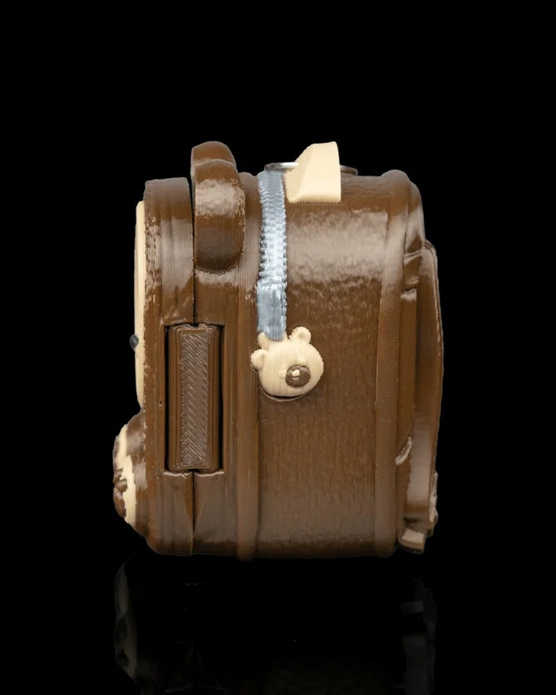 Side view of a brown pack-shaped case with a pale zipper-like detail and small paw pull shape