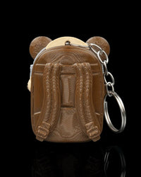 Back view of a brown pack-shaped case with raised strap details and a metal ring and chain at the side