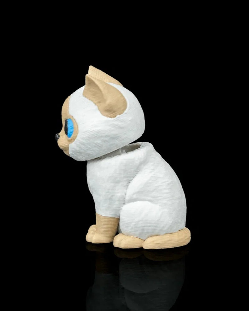 Side view of a cream and white Siamese cat figure with blue eye and tan ear on a black background