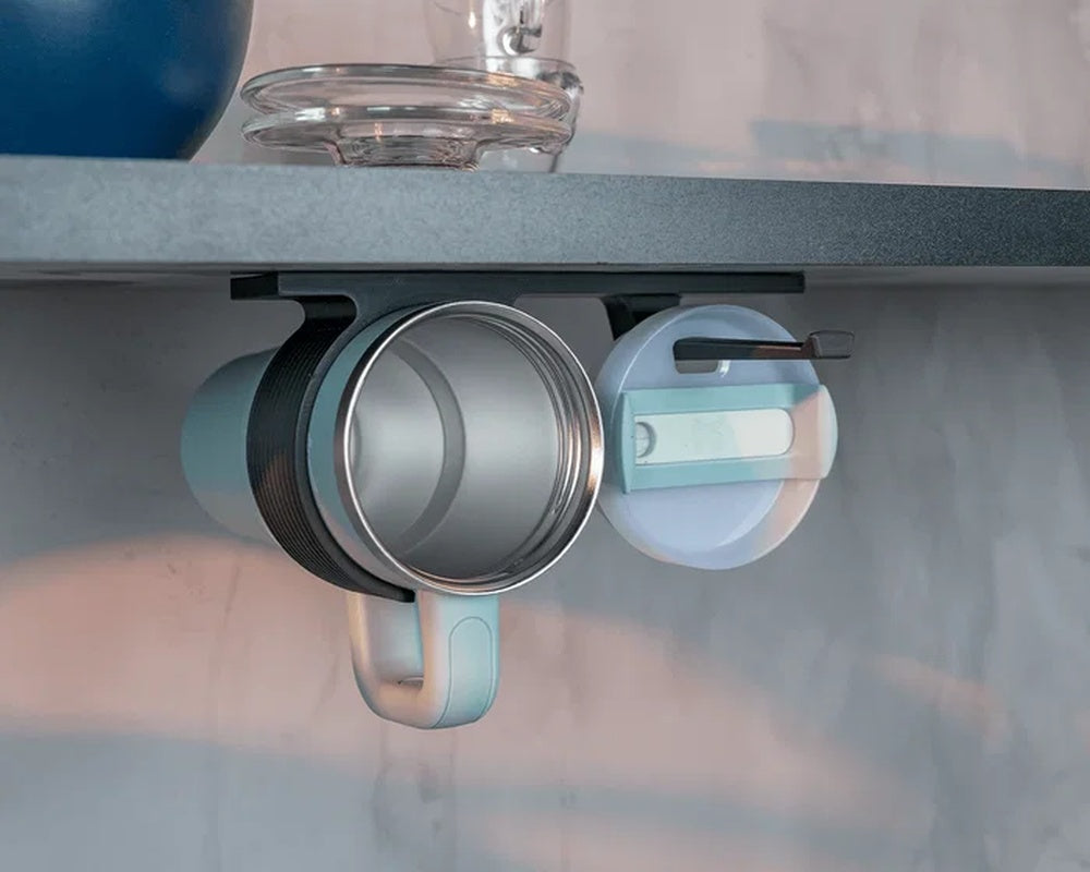 Under-shelf organizer holding a metal cup and round lid under a dark shelf