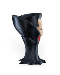 Side view of a small monster figure showing the black raised collar, cloak-like body, and partial pale face on a white background.
