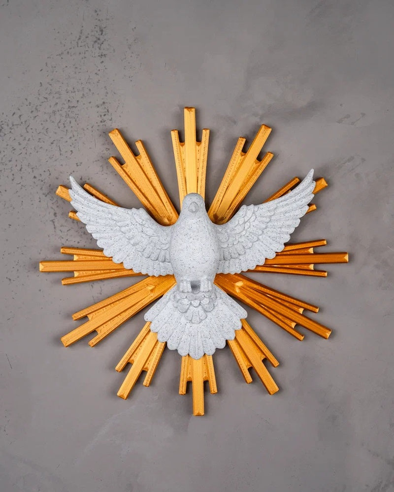 White dove figurine with golden rays mounted on a gray wall